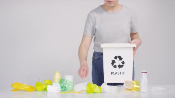 プラスチック製のカップや棒を特殊分別容器に投げ込み さらにリサイクルする若い女性のタイムラプス中間部の映像 — ストック動画