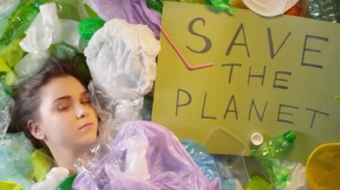 Kafkasyalı genç bir kızın plastiğin üzerinde yatıp Gezegeni Kurtarın tabelasına bakarken çekilen en iyi görüntü.