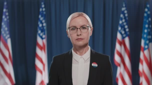 中特写镜头镜头 拍摄成年白种人女人戴着眼镜在镜头前看着相机参加总统选举 — 图库视频影像
