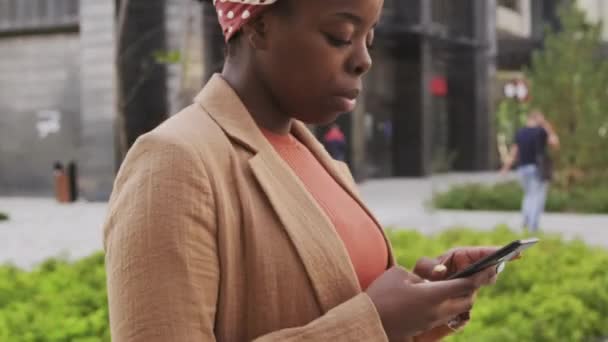 Afro Amerikalı Kadınının Yan Görüntüsü Dışarıda Yürüyor Cep Telefonuyla Yazı — Stok video