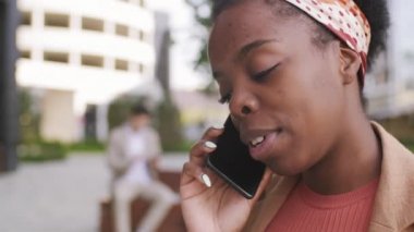  Dışarıda cep telefonuyla konuşan Afro-Amerikalı kadının yavaşlığını kapat.