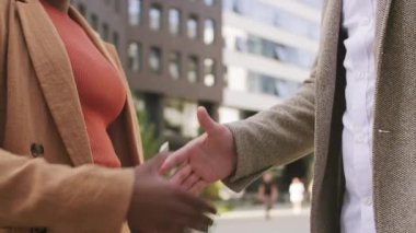  Tanınmayan siyahi iş kadını ve erkek arkadaşının el sıkıştığı orta sınıf bir yavaşlama.