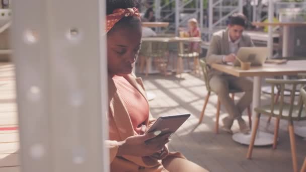 Sledování Záběr Vážné Afroamerické Podnikatelky Tabletem Sedí Venkovní Terase Kavárny — Stock video