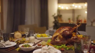 Evde şükran günü kutlaması için hazırlanmış lezzetli yemeklerle dolu yemek masasının kavisli görüntüsü yok.