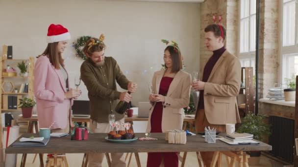 开瓶香槟酒 倒在他快乐的同事们的杯子里 与他们一起庆祝圣诞 — 图库视频影像