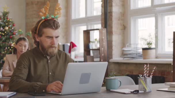크리스마스 사무실에서 책상에 노트북을 휴대폰으로 메시지를 확인하고 밴드를 수염을 사업가의 — 비디오
