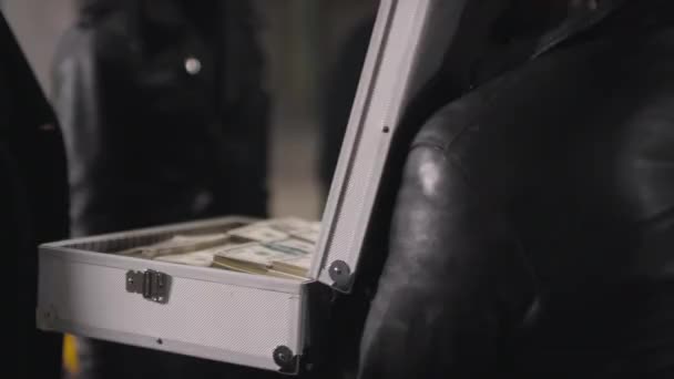 Nerozpoznatelný Zločinec Otevírající Kovovou Aktovku Ukazující Hromady Peněz Jiným Banditům — Stock video