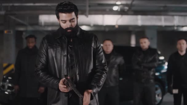 Portret Brodatego Przestępcy Bliskiego Wschodu Patrzącego Przed Kamerę Odświeżającego Pistoletu — Wideo stockowe