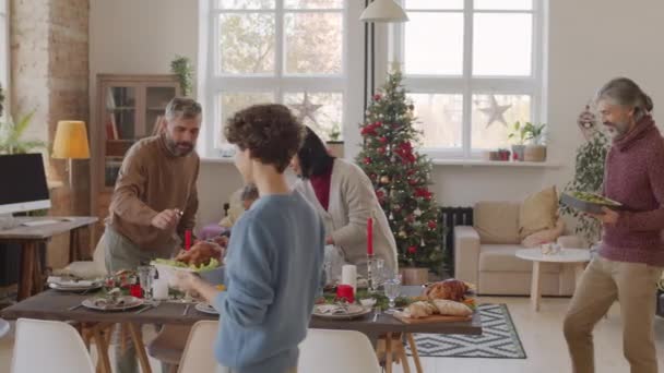 Pan Shot Van Gelukkige Familie Dekken Kersttafel Samen Zetten Borden — Stockvideo