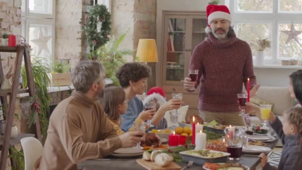 Pan Eines Grauhaarigen Seniors Mit Weihnachtsmütze Der Vor Einem Tisch — Stockvideo