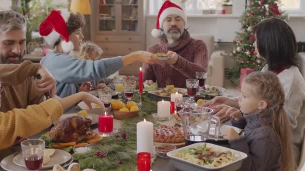 Pan Shot Van Gelukkige Familie Van Zeven Zitten Aan Kersttafel — Stockvideo