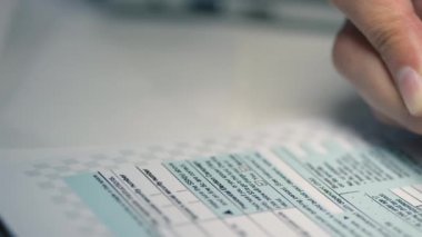 Yazılı vergi beyannamesi formlarını dolduran tanınmayan kadın el kalemi.