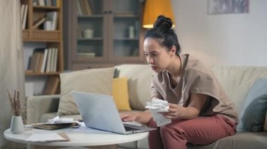 Aylık gelir ve giderleri hesaplayan endişeli genç bir kadının orta ölçekli çekimi bilgisayardaki mali analizler ve büyük harcamalar ve ödemeler hakkında üzülüyor