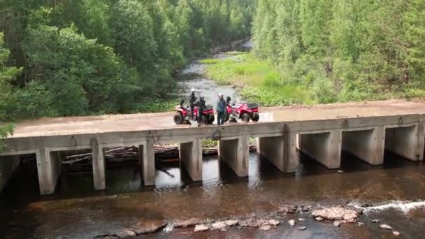 森の中の橋の上に休息ギアに乗るのクワッドバイクドライバーの空中ビュー — ストック動画