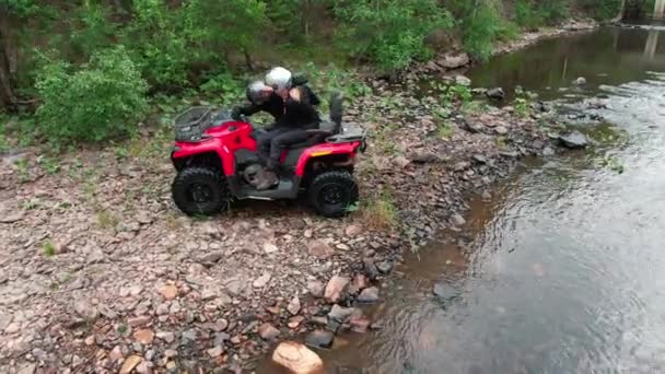 Captura Aérea Seguimiento Feliz Pareja Cascos Sentados Quad Rojo Junto — Vídeos de Stock