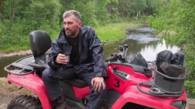 Nehir kenarındaki kırmızı bisikletinin üzerinde oturmuş çay içen sakallı, orta yaşlı bir adamla iz sürüyorum.