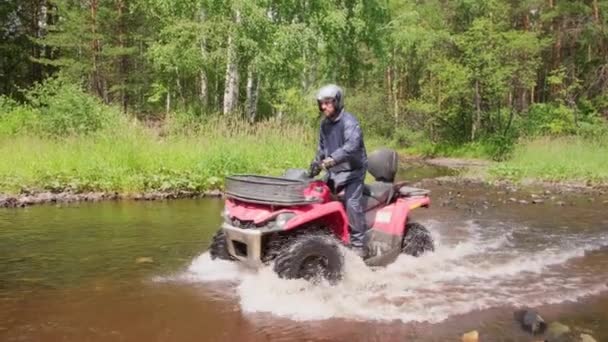 Pomalá Stopa Vousatého Muže Helmě Projíždějící Červenou Čtyřkolkou Řekou Lese — Stock video