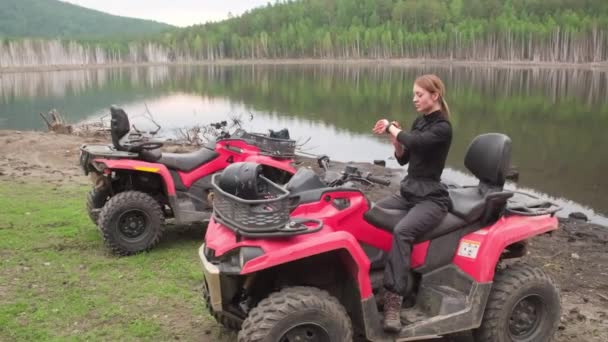 Ручний Знімок Молодої Жінки Сидить Квадроциклі Біля Озера Використовує Смарт — стокове відео
