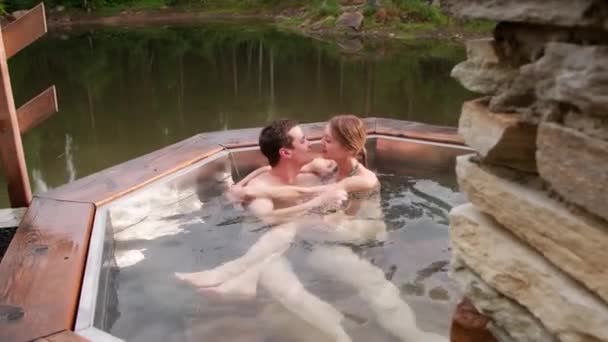 手持式跟踪镜头 一对恋人坐在热水澡里接吻 一边享受浪漫的出游 — 图库视频影像