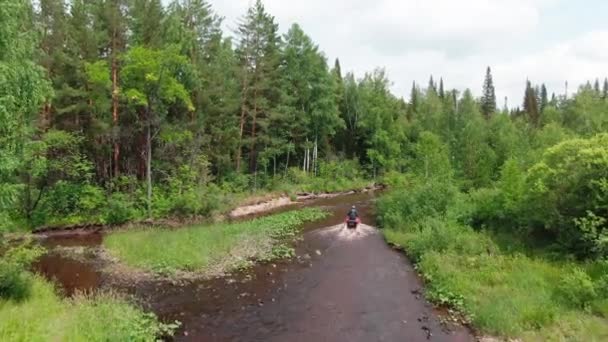 Dron Záběr Nepoznatelný Jezdec Helmě Řízení Červené Čtyřkolky Přes Řeku — Stock video