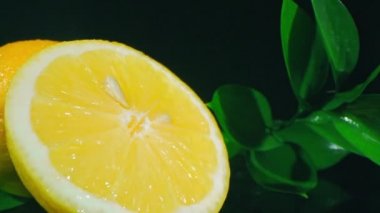 İzole edilmiş parlak sarı limonların, sulu et ve koyu arkaplanda tohum içeren görüntülerini büyüt.