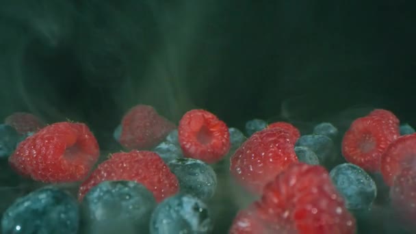 煙の効果と黒の背景に赤と青の果実のマクロショットをドリーアウト — ストック動画
