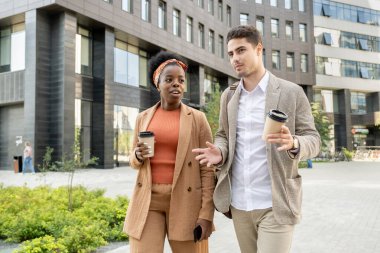 Genç Afrikalı iş kadını, gündelik kıyafetlerini giyer ve tartışma sırasında park boyunca erkek arkadaşının yanına park eder.