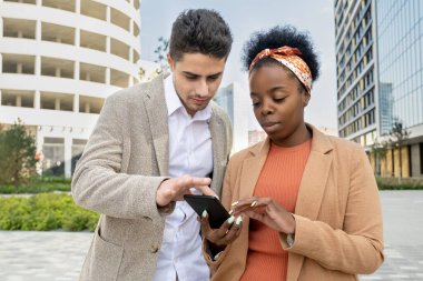 Detayları tartışılırken Afrikalı meslektaşının akıllı telefonuyla ekranına dokunarak genç ve zarif bir iş adamının fotoğrafı büyütüldü.