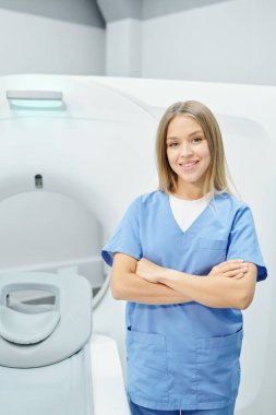 Gülümseyen, kendine güvenen olgun doktor ve genç hemşire, ultrason odasında hasta kartlarını inceliyor.
