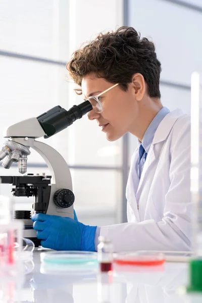Young Woman Whitecoat Gloves Looking Microscope While Studying Charcteristics New — Stock Photo, Image