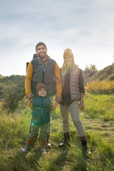 Jonge Vrolijke Ouders Hun Schattige Zoontje Met Rugzakken Groen Gras — Stockfoto