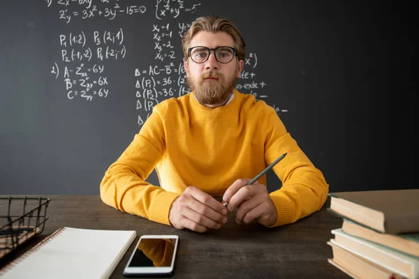 Giovane Insegnante Barbuto Algebra Seduto Tavolo Contro Lavagna Con Formule — Foto Stock