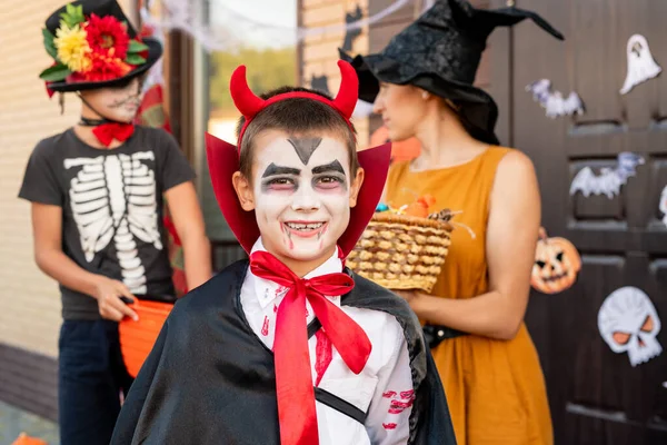 Wesoły Chłopiec Kostiumie Halloween Patrząc Ciebie Przeciwko Młodej Kobiecie Żółtej — Zdjęcie stockowe