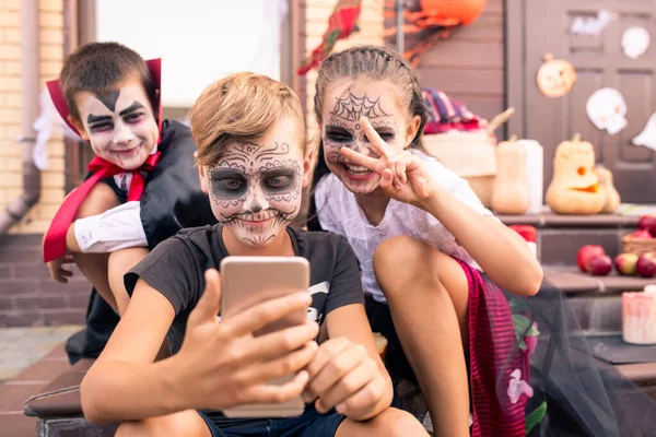 Happy Cute Boy Painted Face Making Selfie While Looking Smartphone — Stock Photo, Image