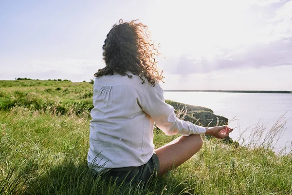 Rear View Curly Haired Woman Sitting Crossed Legs Grass Meditating — Stock Photo, Image