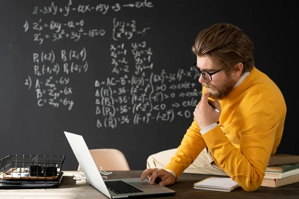 Jovem Professor Contemporâneo Com Caderno Sentado Mesa Frente Laptop Conversando — Fotografia de Stock