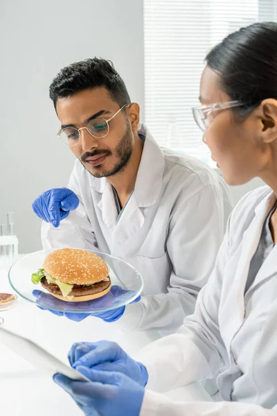 Travailleur Masculin Ganté Contrôle Qualité Des Aliments Pointant Doigt Hamburger — Photo