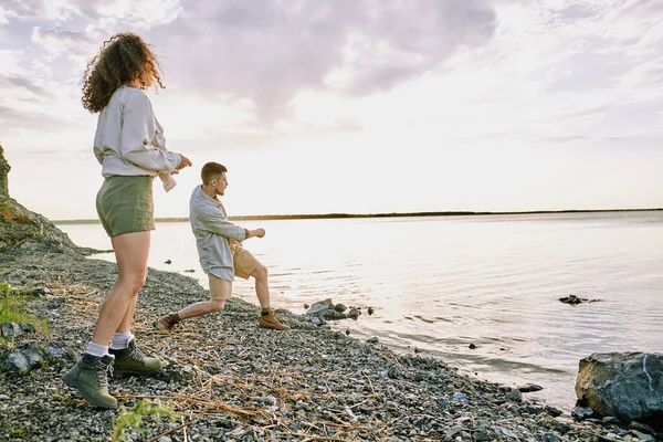 Jonge Man Staan Met Vriendin Aan Meer Kust Gooien Stenen — Stockfoto