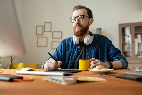 Νέοι Δημιουργικοί Άνδρες Freelance Σχεδιαστής Πίνοντας Ποτό Ενώ Κρατώντας Γραφίδα — Φωτογραφία Αρχείου