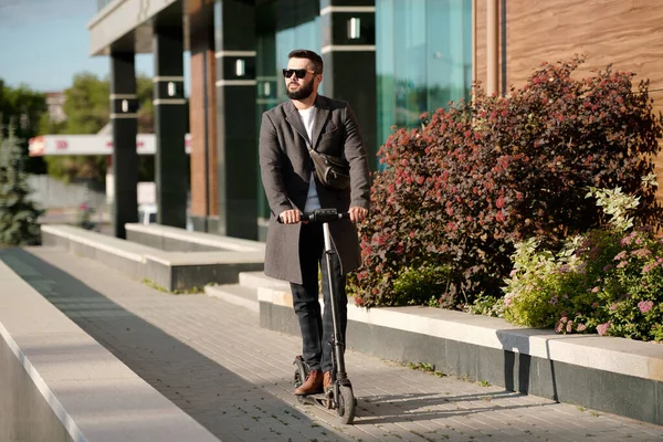 Joven Empresario Barbudo Contemporáneo Abrigo Gafas Sol Cabalgando Scooter Eléctrico — Foto de Stock