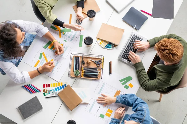 Vista Cuatro Diseñadores Contemporáneos Nuevas Aplicaciones Móviles Sentados Mesa Con —  Fotos de Stock