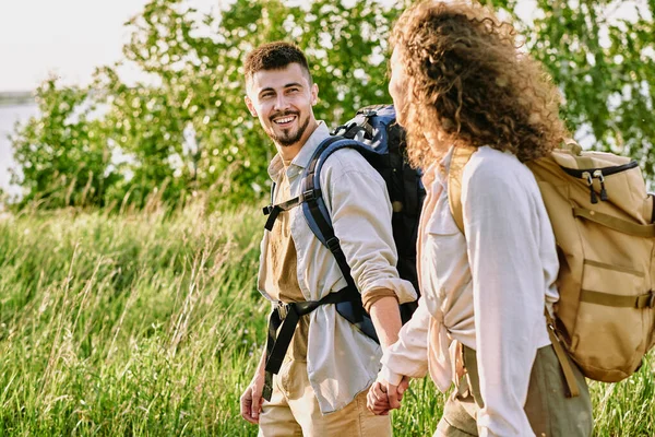 Positivt Ungt Par Med Ryggsäckar Som Håller Varandra Handen Och — Stockfoto