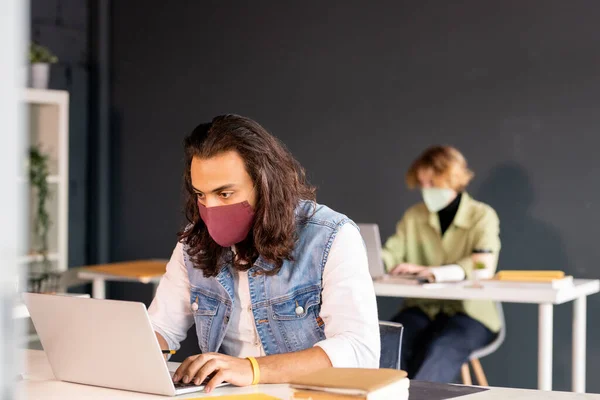 Jovem Empresário Sério Casualwear Máscara Protetora Ligeiramente Dobrando Sobre Mesa — Fotografia de Stock