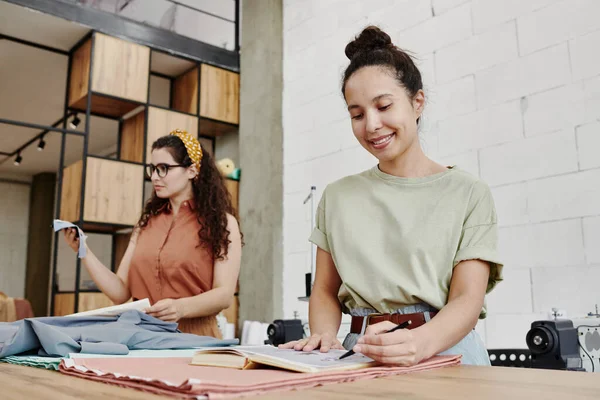 Glückliche Junge Modedesignerin Zeigt Auf Skizze Für Neue Saisonale Kleiderkollektion — Stockfoto