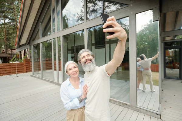 Yakışıklı Yaşlı Sakallı Adam Cam Evin Yanında Selfie Çekerken Karısına — Stok fotoğraf