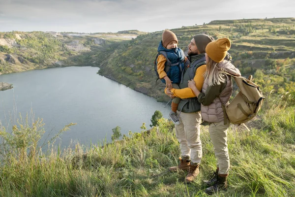 Jonge Ouders Hun Zoontje Met Rugzakken Groen Gras Tegen Meer — Stockfoto