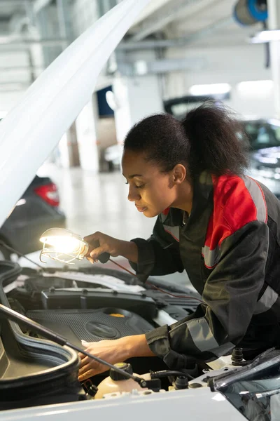 Fiatal Vegyes Fajú Női Technikus Lámpával Nyitott Autó Motortér Fölé — Stock Fotó