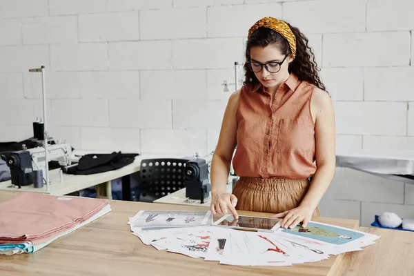 Graziosa Giovane Stilista Donna Con Touchpad Scorrimento Attraverso Nuovi Modelli — Foto Stock