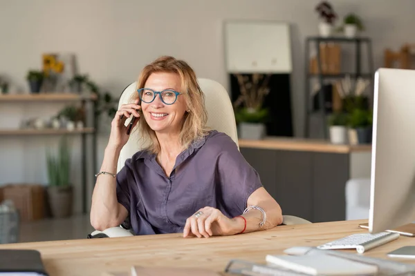 Szczęśliwy Dojrzały Blond Bizneswoman Casualwear Siedzi Przy Biurku Przed Komputerem — Zdjęcie stockowe