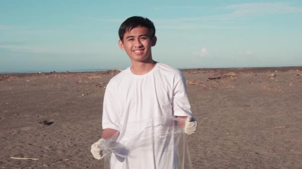 Κοντινό Πλάνο Πορτρέτο Του Νεαρού Χαμογελαστού Άνδρα Κρατώντας Σακούλα Σκουπιδιών — Αρχείο Βίντεο